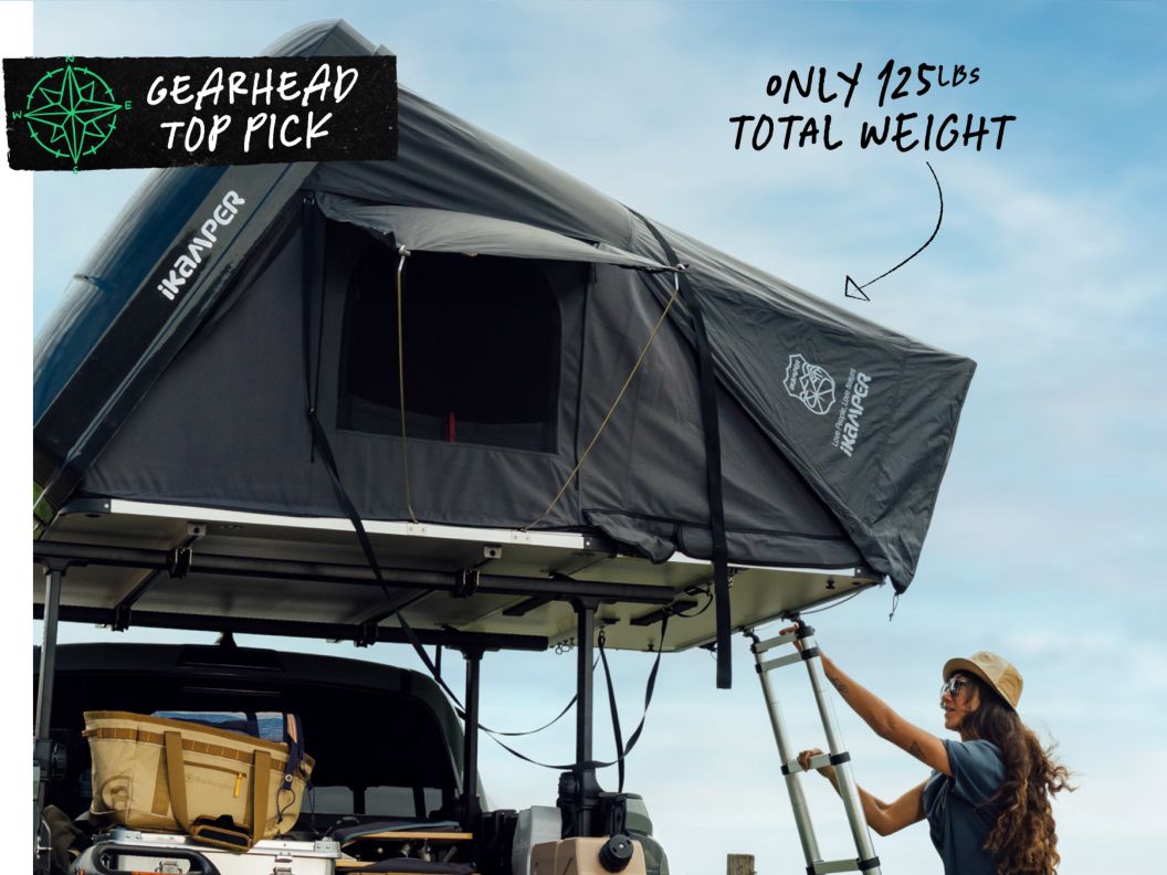 A person climbs up a ladder to a rooftop tent. Text overlay reads: Gearhead top pick, ikamper 3.0 rooftop tent.
